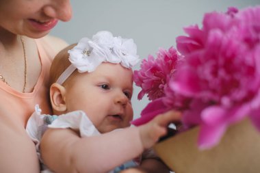 Mutlu genç onun yeni doğan çocuk anne ve çiçekler Buket gösterilen dünya keşfetmek yardım