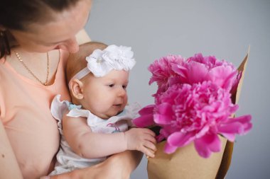 Mutlu genç onun yeni doğan çocuk anne ve çiçekler Buket gösterilen dünya keşfetmek yardım