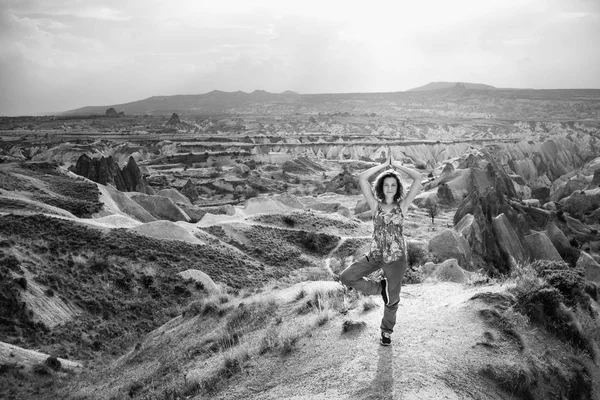 Woman practice tree yoga pose in nature. Black and white Cappadocia mountain landscape with beautiful sky