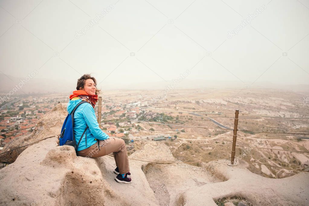 Young tourist woman in Uchisar enjoying landscape from the castle in Cappadocia. Travel to Cappadocia, Turkey