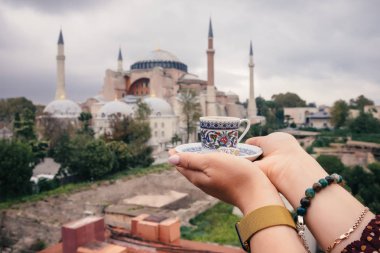 Türkiye'nin turist kadın kahve fincan eller üzerinde ünlü İslam Landmark Camii Ayasofya Müzesi, Istanbul, Türkiye'nin arka plan seyahat