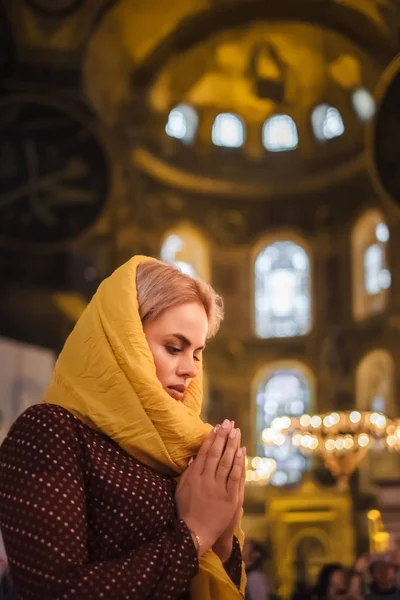 Christian Religion Concept. Young woman praying and feel God blessing in her heart in Hagia Sophia, Istanbul, Turkey