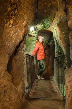 Güzel turist kadın keşfetmek antik Kaymaklı yeraltı cave City uzun dar tünel. Türkiye'ye seyahat