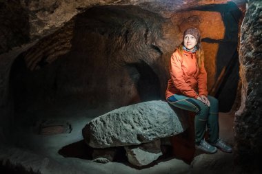 Güzel turist kadın keşfetmek antik Derinkuyu yeraltı cave City uzun dar tünel. Türkiye'ye seyahat