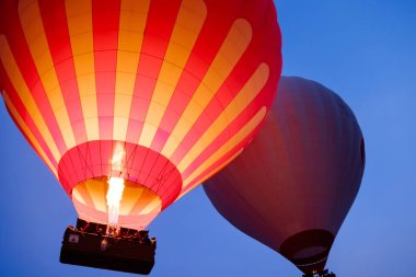 Yakın çekim renkli büyük sıcak hava balonları güzel Göreme köyü peyzaj üzerinde güneş doğarken uçan. Cappadocia güzel dağlar, Türkiye. Tahıl ile yüksek ISO görüntü