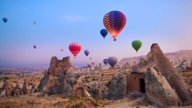 Yakın çekim renkli büyük sıcak hava balonları güzel Göreme köyü peyzaj üzerinde güneş doğarken uçan. Cappadocia güzel kalker Dağları, Türkiye ile ünlü seyahat yer