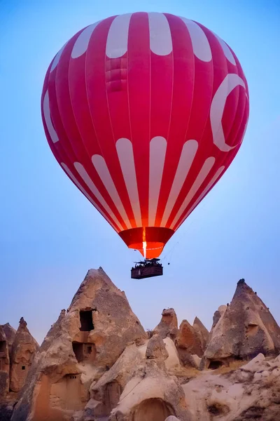 Beautiful hot air balloons flying over beautiful Goreme landscape at sunrise on blue sky background. Cappadocia is famous travel destination with limestone mountains, Turkey