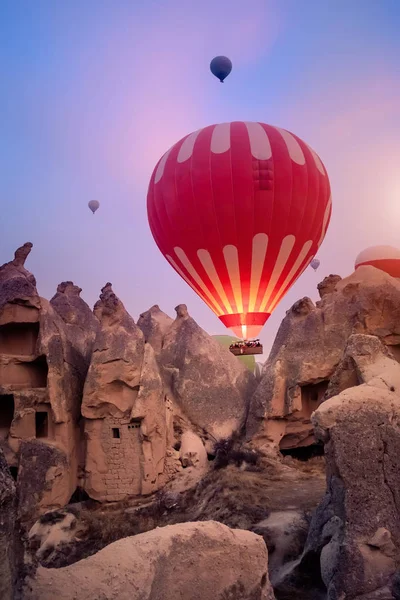 Close-up colorful big hot air balloons flying over beautiful Goreme village landscape at sunrise. Cappadocia is famous travel destination with beautiful limestone mountains, Turkey