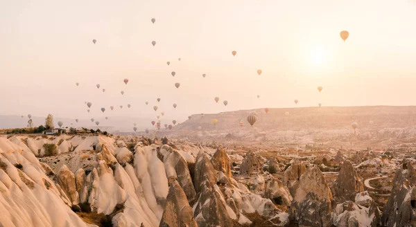 Beautiful hot air balloons flying over beautiful Goreme landscape at gold sunrise. Cappadocia is famous travel destination with limestone mountains, Turkey