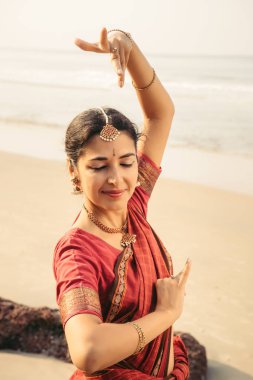 Hint Klasik dans Bharatanatyam gün batımında geleneksel giysiler içinde güzel bir kadın tarafından gerçekleştirilen