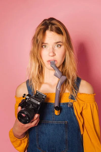 Retro style fashionable woman with film camera on pink backgroun — Stock Photo, Image