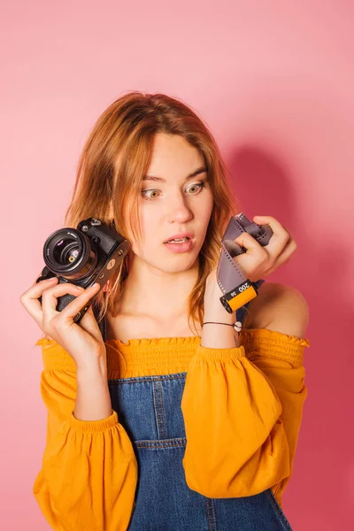 Estilo retro mujer de moda con cámara de cine sobre fondo rosa — Foto de Stock