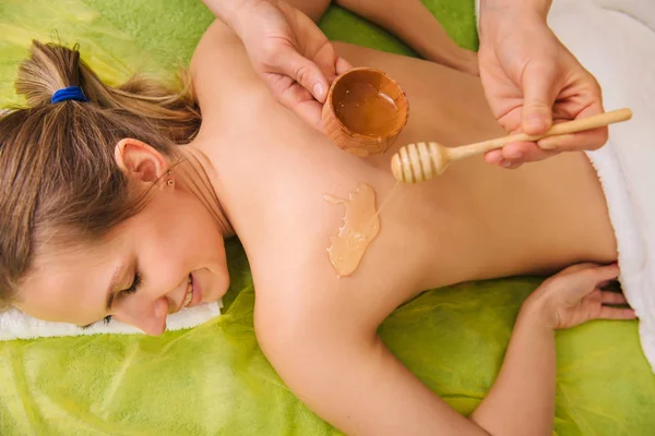 Молода жінка насолоджується курортним лікуванням з медом — стокове фото