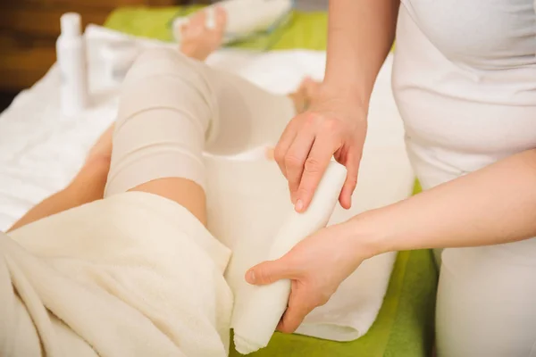 Procédure anti-cellulite enveloppements pour les jambes dans un centre de spa — Photo