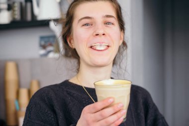 Genç kız tat kahve latte ve yalamak köpük gelen dudaklar