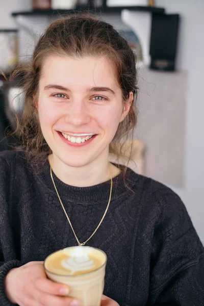 Chica joven sonrisa y sabor café con leche — Foto de Stock