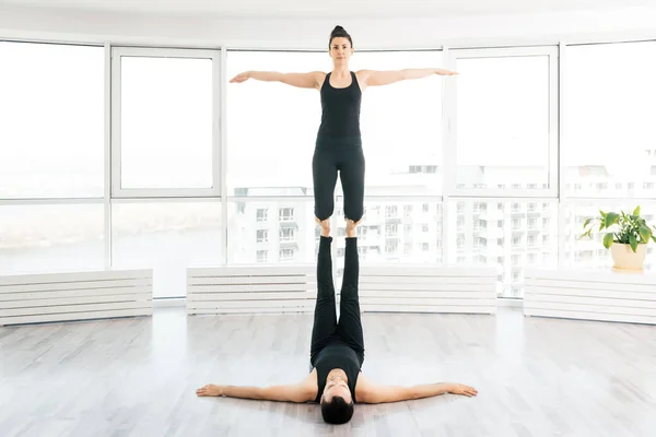 Donna positiva pratica acro yoga con partner uomo in studio — Foto Stock