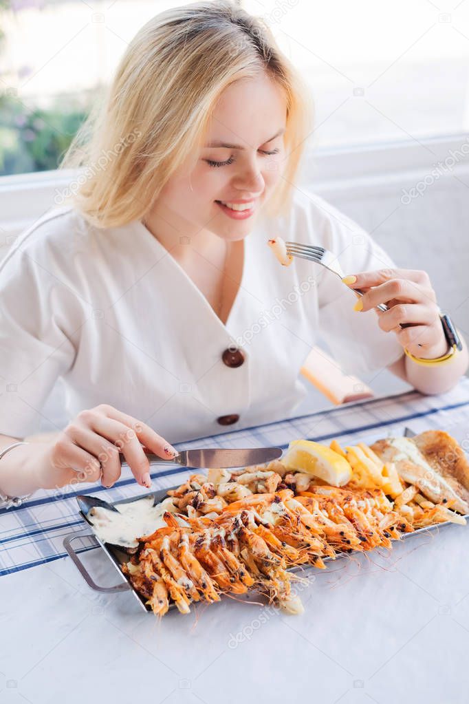 Cyprus cuisine, woman eat tasty grilled shrimps