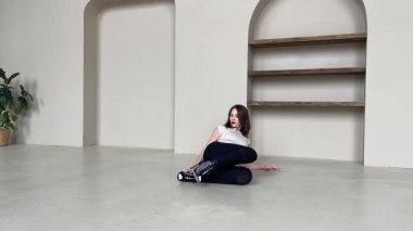 Parlak, modern bir stüdyoda zarif bir yüksek topuklu dans gösterisi yapan kadın..