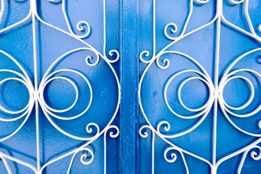 Beyaz metal süslemeli mavi ahşap kapılar.