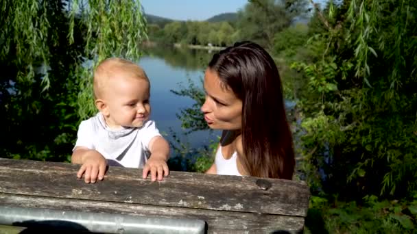 Egy Kedves Anya Egy Kisbaba Egy Padon Egy Szép Tónál — Stock videók