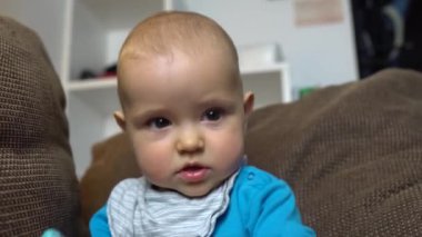 Oynayan ve kameraya gülümseyen sevimli bir çocuğun yakın çekimi. 4K