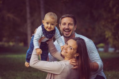 Piknikte mutlu bir aile. Bebek, anne ve baba dışarıda doğada..