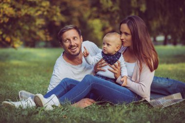 Piknikte mutlu bir aile. Bebek, anne ve baba dışarıda doğada..