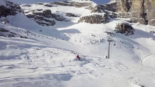 Narciarz machający na pożegnanie podczas lotu dronem w ośrodku narciarskim Cortina Dampezzo — Wideo stockowe