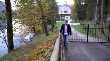 Bir işadamı evinden bir göl kenarında yürüyor.