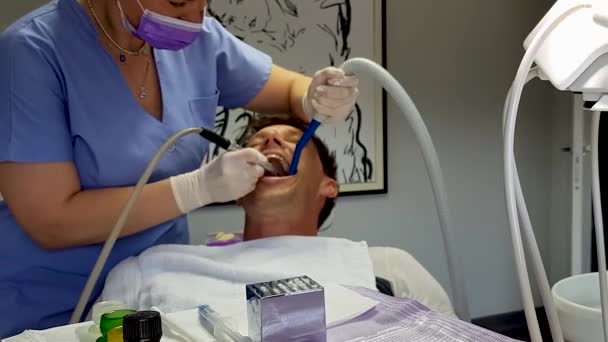歯科医は 歯科ドリルと吸引ツールで患者を治療します — ストック動画