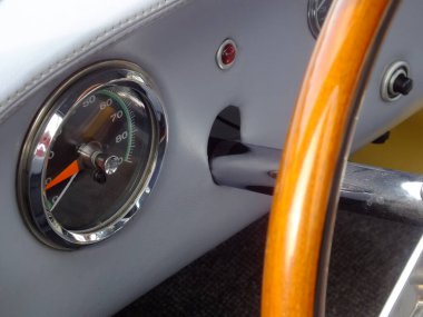 Tahta direksiyonun ve devrim tezgahının bulunduğu klasik bir yarış arabasının kokpitinin yakın çekimi.