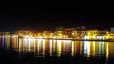 CHIOS, GREECE, 14 Eylül 2017. Yunan adası Chios 'un limanının panoramik gece manzarası ve sudaki renkli şehir ışıklarının yansımaları.