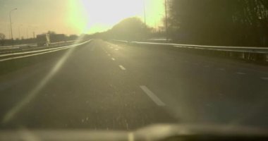 Hareket halindeki bir arabanın gösterge panelindeki ışık huzmelerinde bir fincan kahve.