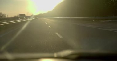 Hareket halindeki bir arabanın gösterge panelindeki ışık huzmelerinde bir fincan kahve.