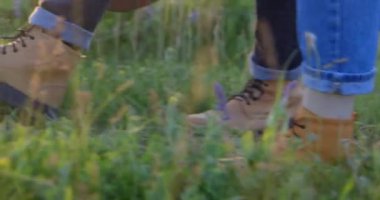 Erkek çizmeleriyle çimenlerde yürüyorum.