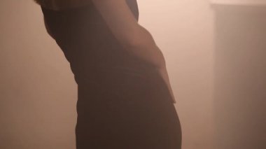 Kız yakın plan, ışığın altında kendine dokunuyor.