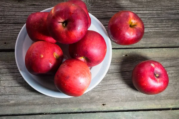 Tahta arka planda kırmızı elmalar