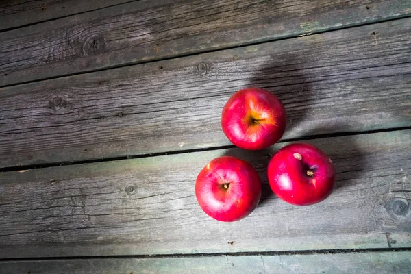 Tahta arka planda kırmızı elmalar