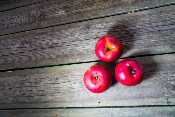 Tahta arka planda kırmızı elmalar
