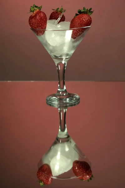 Ένα Ψηλό Ποτήρι Μαρτίνι Κομμάτια Πάγου Και Φράουλας Κόκκινο Φόντο — Φωτογραφία Αρχείου