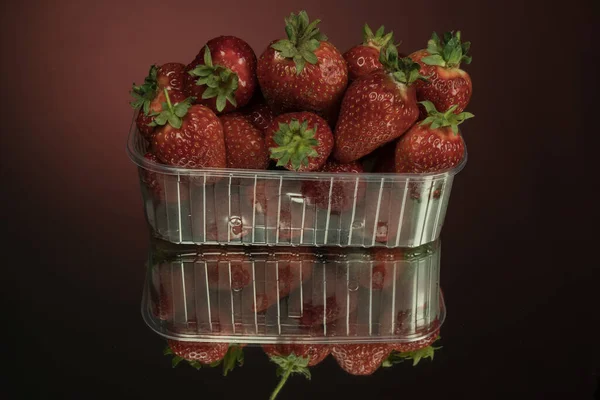 Verse Aardbeien Een Doorzichtige Plastic Doos Een Spiegelrode Achtergrond Aardbeien — Stockfoto