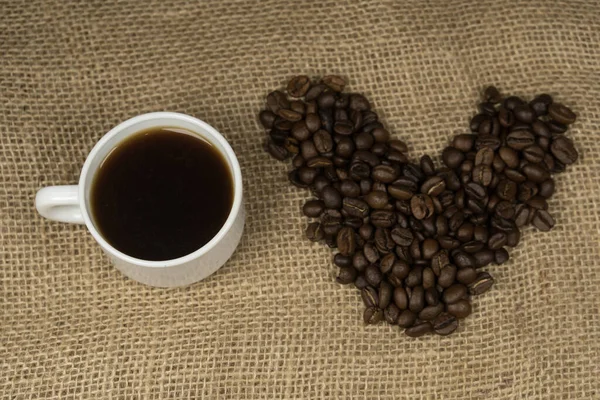 コーヒー豆にスプーンとコーヒーのカップから作られたハートの形は 私はコーヒーが大好きです — ストック写真