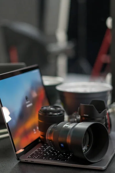 Dijital kamera, lens ve laptop. Fotoğrafçı çalışma istasyonu konsepti. Evde çalışıyorum..