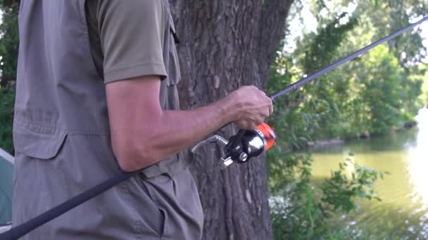 雄的手在钓鱼的时候扭动纺锤 旋转卷轴特写 鲤鱼捕捞 — 图库视频影像