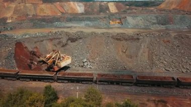 Kazıcı taş ocağı tren demir cevheri madenciliğini yüklüyor.