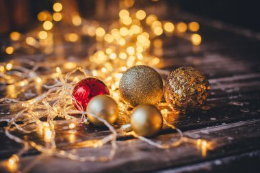 Noel süslemeleri kırmızı ve altın toplar sarı ışıkların arka planında