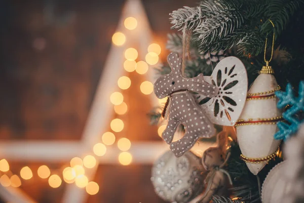 Noel ağacı süslenmiş, sarı ışıklı eski püskü Noel oyuncağı süslemesi.