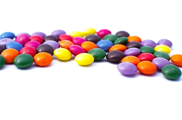 在有限的白色背景上散布的彩色糖果 — 图库照片