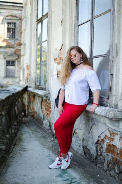 Arka planda kıvırcık saçlı genç gülümseyen kız